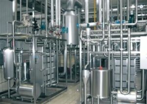 Ценность молока, как и любого другого пищевого продукта, определяется его качеством. Качественные характеристики, в свою очередь, зависят от целого ряда факторов: здоровья животных, условий содержания, доения, правильной санитарной обработки оборудования и скорости охлаждения полученного молока. Последнему условию на молочных фермах и молокоперерабатывающих предприятиях уделяется максимум внимания, так как именно неэффективное охлаждение чаще всего приводит к ситуации, когда экстра сорт продукции становится вторым или даже третьим. Типы охлаждения и холодильное оборудование Температура очень сильно влияет на количество бактерий в сыром (не пастеризованном) молоке. Быстрое понижение температуры замедляет или полностью прекращает их развитие, потому настоятельно рекомендуется начинать снижать температуру молока сразу после дойки. Температура для хранения сырья между операциями доения не должна превышать +4 градуса Цельсия. Сегодня можно выделить два основных типа охлаждения молока, каждый из которых имеет свои особенности: 1. Естественное – наиболее простой вариант, подразумевающий охлаждение водой и льдом. Требует достаточно большого расхода ресурса (пресной воды), потому одновременно считается и самым дорогостоящим. Однако, если подогретую при использовании воду повторно применять для бытовых и технических нужд, этот метод становится более практичным. 2. Искусственное – выполняется специальными холодильными установками с различным принципом работы. Система с непосредственным охлаждением на данный момент является самой распространенной. Основные ее преимущества это простота в эксплуатации, высокий КПД и достаточно небольшие габаритные размеры. Основным недостатком можно выделить - достаточно медленное охлаждение молока. Мгновенное охлаждение молока (охлаждение в потоке) В настоящее время спрос на молочную продукцию значительно возрос, а это ведет к увеличению поголовья коров и соответственно молока. Следовательно, в разы больший объем молока необходимо охладить за единицу времени. Для реализации данной задачи используют системы мгновенного охлаждения или как их еще называют охлаждение в потоке. Эти системы служат для охлаждения молока за считанные секунды, до того как оно поступит в танк. Процесс охлаждения происходит непосредственно в пластинчатом теплообменнике, который состоит из стальных рифленых пластин, по одной стороне которых течет молоко, а по другой стороне вода с температурой 0,5…1,5 оС. Для получения ледяной воды наиболее часто используют два типа холодильного оборудования – пленочные испарители или льдоаккумуляторы. Пленочные испарители. Работа пленочного испарителя, а точнее его особенность состоит в следующем – охлаждаемая вода попадает в емкость над пластинами испарителя, в которой через перфорированные каналы стекает по секциям испарителей, образуя равномерную жидкостную пленку, при стекании воды, из-за кипения фреона внутри секций, образуется слой льда. Далее лед отслаивается и падает в буферный накопитель, который соединен с системой циркуляции воды идущей на пластинчатый теплообменник задействованный в охлаждении молока. Таким образом вода отобравшая в пластинчатом теплообменнике тепло у молока передает свою тепловую энергию на плавление льда и снова охлаждается до температуры 0,5…1,5 оС. Льдоаккумуляторы. Льдоаккумулятор представляет собой теплоизолированную емкость внутри которой расположены секции трубчатых испарителей, на поверхности которых, происходит намораживание льда. Вода после охлаждения молока в пластинчатом теплообменнике поступает в льдоаккумулятор, где снова охлаждается за счет таяния льда наморозившегося на секциях испарителя. Далее охлажденная вода с температурой 0,5…1,5 оС опять поступает на пластинчатый теплообменник для отбора тепла у продукции. Данная система способна охладить молоко с температуры равной +32 оС до +4 оС за считанные секунды. Специалисты нашей компании имеют необходимый опыт в расчете холодопроизводительности, массы необходимого аккумулирования льда, периода регенерации льда данных систем охлаждения молока. Также данные системы нашли широкое применение для получения ледяной воды при производстве кваса, пива, охлаждения тузлука. Пленочные испарители и льдоаккумуляторы можно применять как отдельными системами охлаждения так и в комбинированной схеме охлаждения. Выше приведенные системы мгновенного охлаждения молока наиболее эффективно применять для погашения пиковых тепловых нагрузок предприятий. Они характеризуются высокой надежностью и экономным потреблением электроэнергии, так как исходя из графика тепловых нагрузок, намораживание льда происходит в ночное время суток при льготном тарифе на электроэнергию. На сегодняшний день наличие молочного холодильного оборудования – обязательное условие для любого крупного предприятия, занимающегося переработкой молока и производством молочных продуктов. Оно не только эффективно, легко регулируется и длительное время поддерживают заданную температуру молока, но и достаточно экономно в плане потребления энергоресурсов, что особо выгодно в условиях нынешней экономической ситуации в стране.